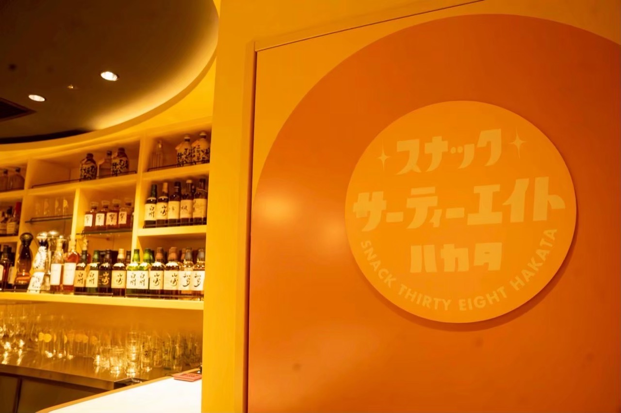 博多店のロゴ:お店のカラーに合わせた壁面のサイン。